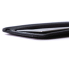 Close-up of a black minimalist card wallets holding a slim silver card, photographed on a clean white background. all-groups